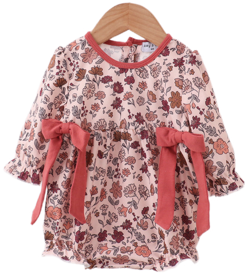 Two baby girl autumn outfits in soft corduroy with warm floral prints. One is a romper with ribbon details, and the other is a pants and top set, both in matching fall tones.