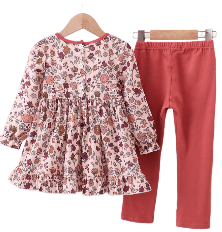 Two baby girl autumn outfits in soft corduroy with warm floral prints. One is a romper with ribbon details, and the other is a pants and top set, both in matching fall tones.